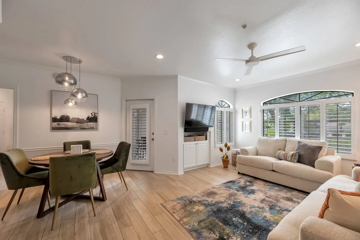 This cozy Scottsdale condo interior features a welcoming open layout with a stylish dining area, plush sofa, and a flat-screen TV, all bathed in natural light from expansive windows. The space is perfectly set for intimate dinners, relaxing movie nights, and social gatherings, creating an inviting atmosphere for up to four guests.